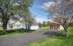 a driveway in front of a house with trees at Center Hill Cottage in Smithville