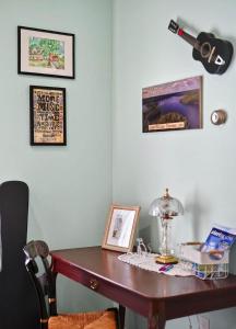 a desk in a room with a guitar on a wall at Center Hill Cottage in Smithville