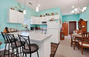 a kitchen with white cabinets and a table and chairs at Center Hill Cottage in Smithville +1 photo