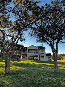 a large white house with trees in front of it at Acacia House in Winterton