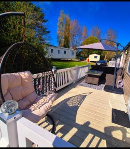 a patio with a couch and an umbrella at Denny's Holiday Homes in Blackpool