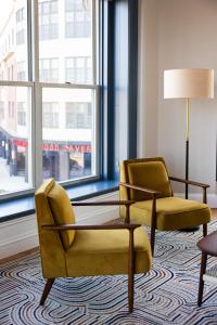 a living room with two chairs and a table and a window at The Courier Hotel in Salem +34 photos