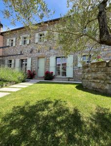 a stone house with a tree in front of it at Hiša Marija Private Spa Villa in Zgornje Škofije