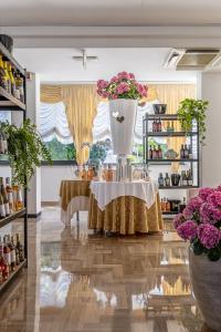 a vase with flowers on a table in a room at CASA MAJOR Hotel & Appartamenti CERVIA in Cervia