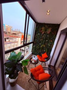an apartment balcony with orange chairs and plants at Votre escapade d été à deux pas de la plage in Kenitra