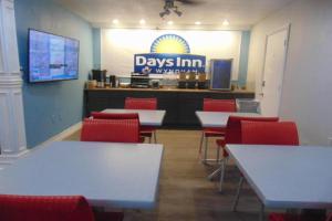 a dining room with tables and red chairs and adays inn restaurant at Days Inn by Wyndham Victorville - Hesperia I-15 Palmdale Road in Victorville