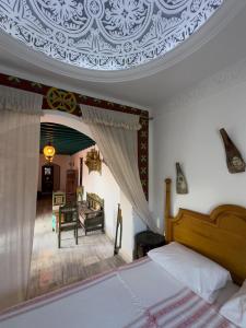 a bedroom with a bed and a living room at Houch Ennejma, Chambres d'hotes, Spa et bien être in Al Ḩārah al Kabīrah