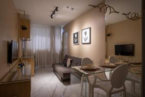 a living room with a couch and a table with chairs at Studio completo estilo casa com lava e seca, Go Inn in Brasília