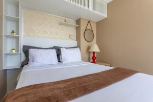 a bedroom with a large white bed with white pillows at Studio completo estilo casa com lava e seca, Go Inn in Brasília +24 photos