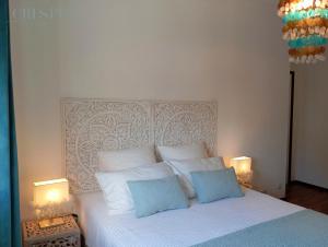a bedroom with a white bed with two blue pillows at Casa Crespim in Monção