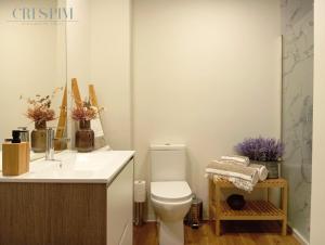 a white bathroom with a toilet and a sink at Casa Crespim in Monção +5 photos