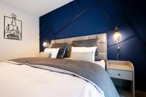 a bedroom with a large bed with a blue wall at Ferienwohnung RaiKa in Moers