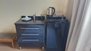 a kitchen with a sink and a blender and a dresser at Suíte Individual, ampla, aconchegante e com 2 ventiladores! in Vitória