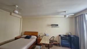 a bedroom with two beds and a desk with a basketball hoop at Suíte Individual, ampla, aconchegante e com 2 ventiladores! in Vitória