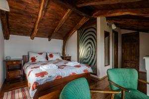a bedroom with a bed and two green chairs at Refugio Ivanini in Zagorje +20 photos