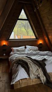 a large bed in a room with a window at BRUN Cabin in Şotrile