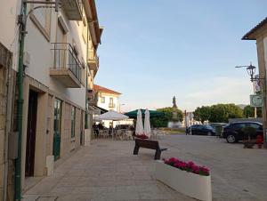 a street with a bench and a table and chairs at Casa Crespim in Monção