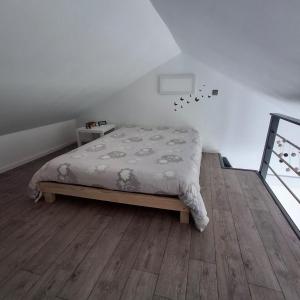 a bedroom with a bed and a wooden floor at maison de vacances gite duplex in Erquy