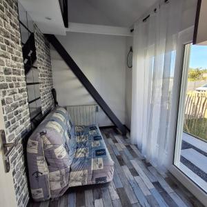 a living room with a couch and a large window at maison de vacances gite duplex in Erquy +6 photos