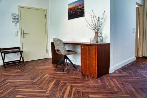 a desk with a chair and a vase on it at Parkhotel Steimker Berg Wolfsburg in Wolfsburg