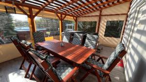a wooden table and chairs on a screened in porch at ReZa111 in Békésszentandrás