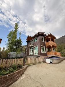 a large wooden house with a wooden fence at Haari Wann in Srinagar