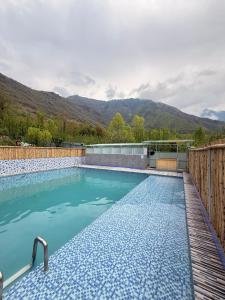 a swimming pool with mountains in the background at Haari Wann in Srinagar