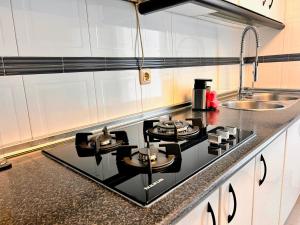 a kitchen with a black stove top in a kitchen at Apartment with private parking included - Granada in La Zubia