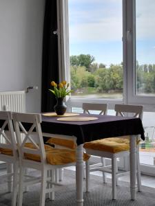 a dining room with a table and chairs and a window at Duna Kuckó in Mohács