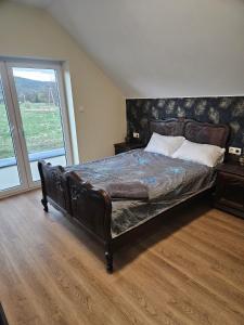 a large bed in a bedroom with a large window at Harmonia in Radochów