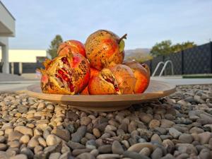 a bowl of pomegranates on a plate on rocks at Villa Vento Mostar in Mostar