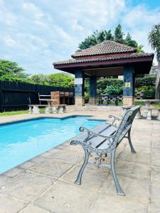 a bench next to a swimming pool with a gazebo at 15 Surabaya in Margate