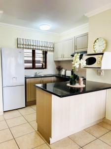 a kitchen with a white refrigerator and a counter top at 15 Surabaya in Margate