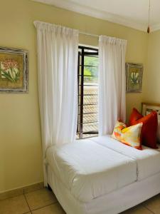 a bedroom with a bed with white sheets and a window at 15 Surabaya in Margate