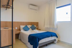 a bedroom with a bed with blue sheets and a window at Bananeiras Solar in Bananeiras