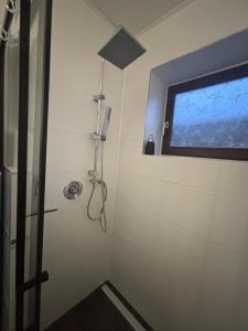 a shower in a bathroom with a window at Ferienwohnung Waldblick in Winterberg +13 photos