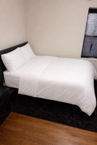 a white bed with white sheets and pillows at Anne room A in Irvington