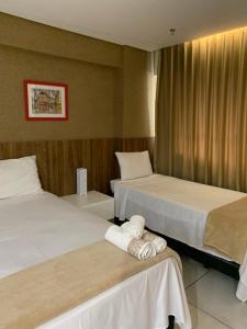 a hotel room with two beds and two towels at Prime Flats in Palmas +12 photos