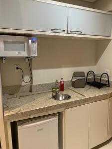 a kitchen counter with a sink and a microwave at Prime Flats in Palmas