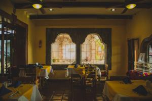 a dining room with tables and a stained glass window at Hotel Cosmos Don Carlos in Mexicali