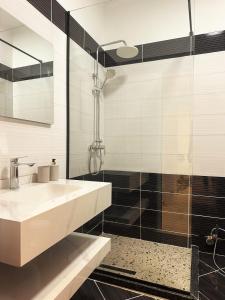a bathroom with a sink and a shower at DuoNest-BoHo Sunset in Tirana