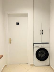 a white door with a washing machine in a room at DuoNest-BoHo Sunset in Tirana