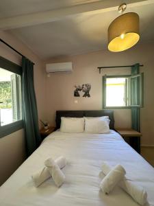 a bedroom with a large bed with two pillows on it at Pine and Sea in Artemida