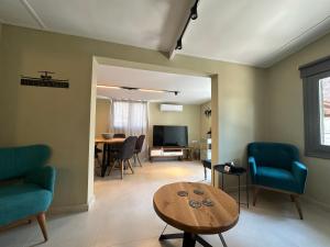 a living room with blue chairs and a table at Pine and Sea in Artemida