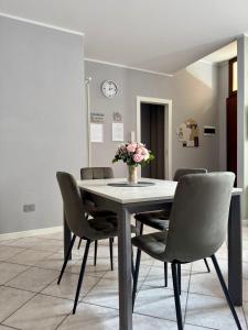 a dining room table with chairs and a vase of flowers at Le Scuderie - casa vacanze in Intra