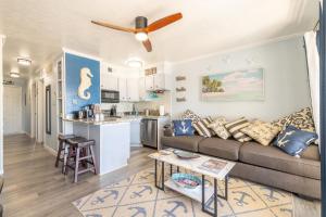 a living room with a couch and a kitchen at Casa Del Mar 231 - Ocean View Family Retreat on Seawall in Galveston