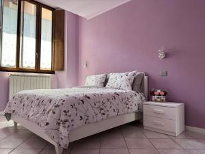 a bedroom with a bed with a purple wall at Le Scuderie - casa vacanze in Intra +8 photos