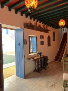 a room with a table and a window and stairs at Houch Ennejma, Chambres d'hotes, Spa et bien être in Al Ḩārah al Kabīrah
