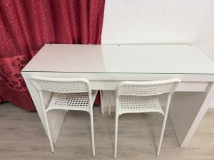 a white table and two chairs next to a curtain at Hotel Eurorooms in Rome