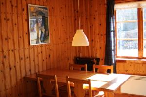 a dining room with a wooden table and chairs at Comfortable and cozy cottage in Sysslebäck